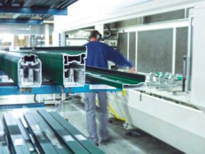 Horizal Factory showing an aluminium profile on the shelf with an engineer working on a work bench with ear defenders on