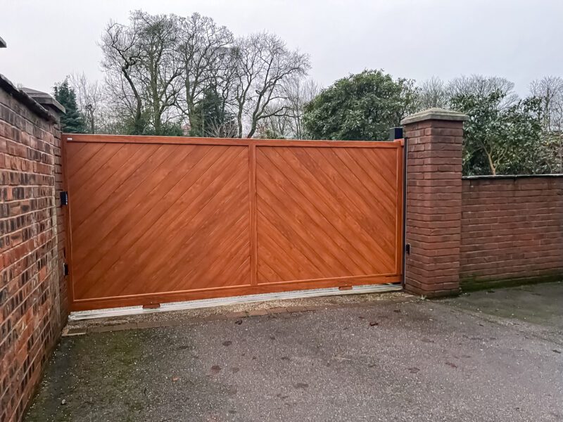 Wooden Driveway gate in aluminium between brick pillars with sliding automation