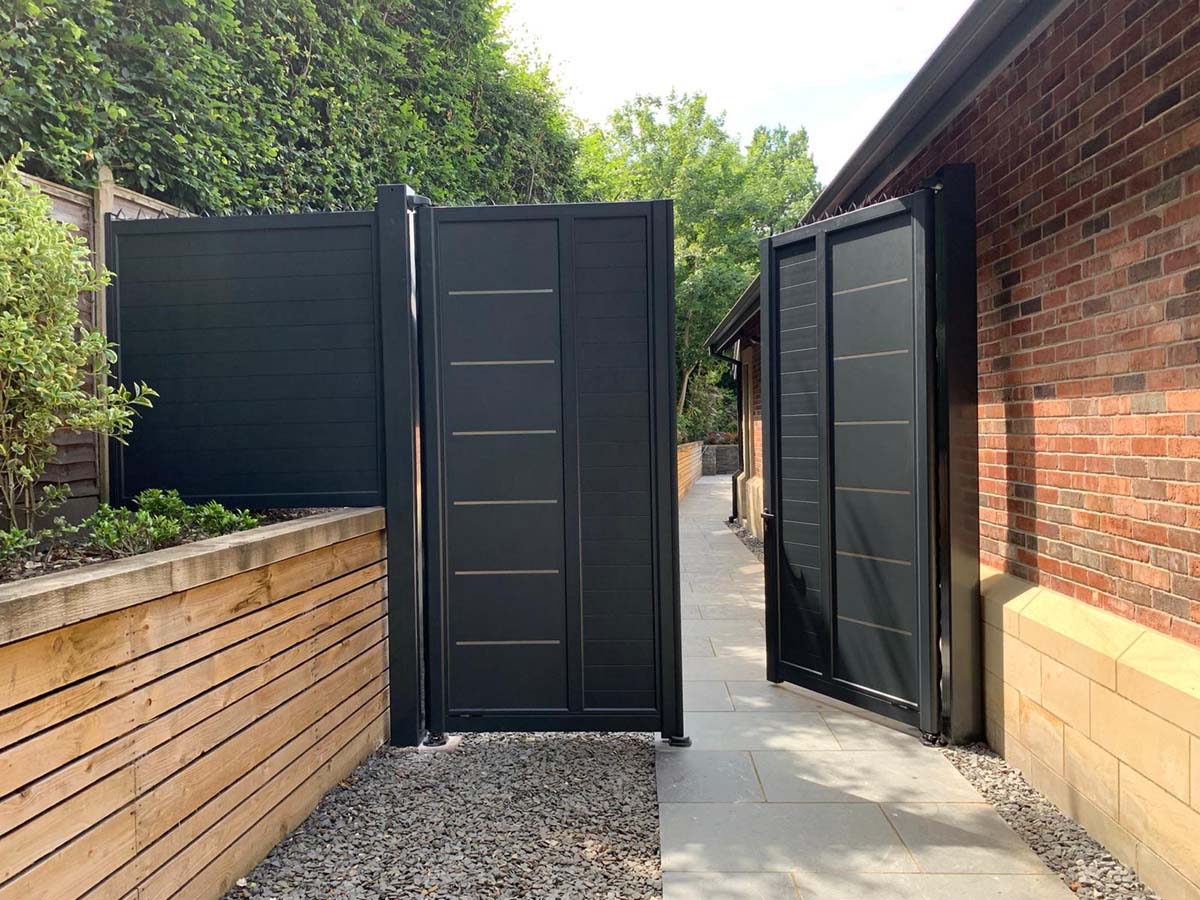 Tall garden gates fixed to the side of the house with vandal spikes onto the top to deter climbing