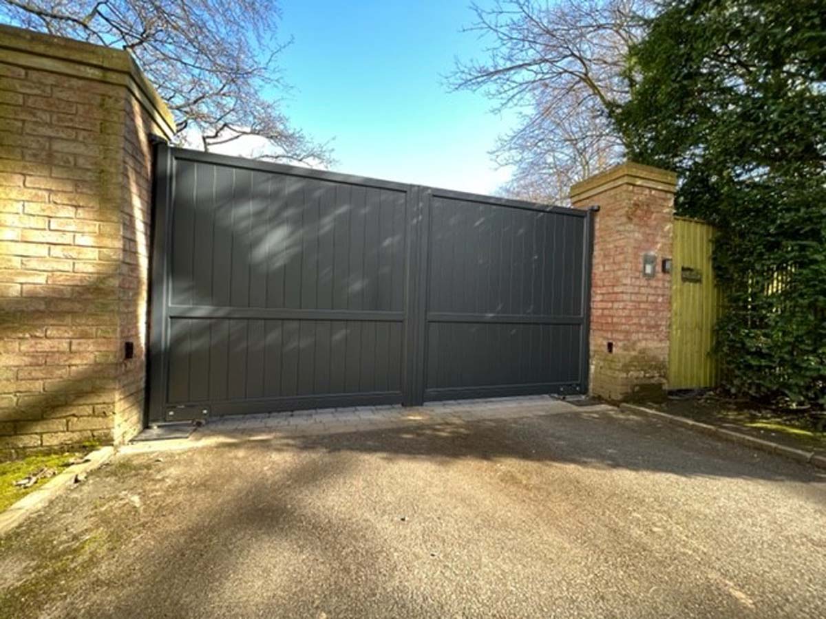 large grey aluminium driveway gates with underground motors